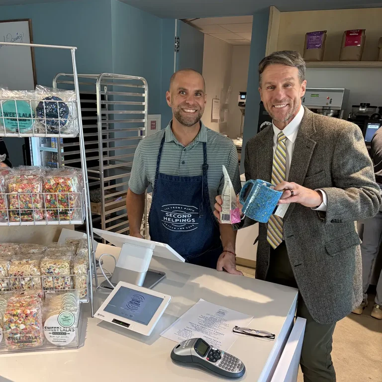 Customer purchasing a blue mug and a package of treats at the payment counter in Second Helpings Café Memphis