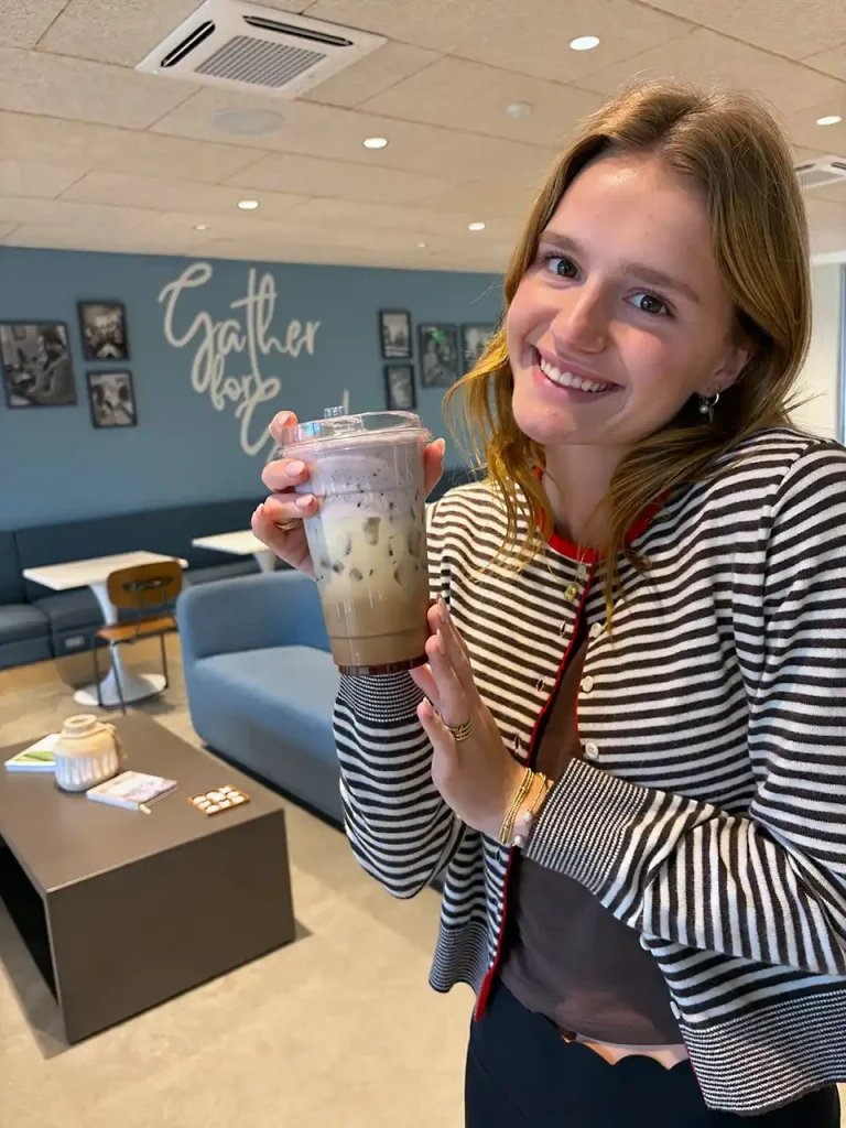 Young girl enjoying iced coffee in the family-friendly dining area at Second Helpings Café